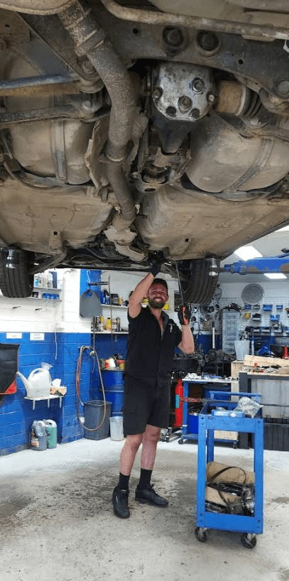 Charlie working under a hoisted car